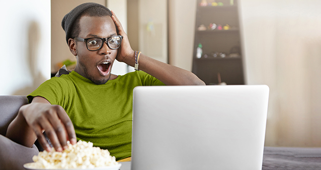 man eating popcorn while watching a movie