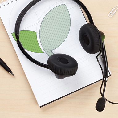Headphones on top of a notepad on a table | History of DebtSafe | Hippo.co.za partner