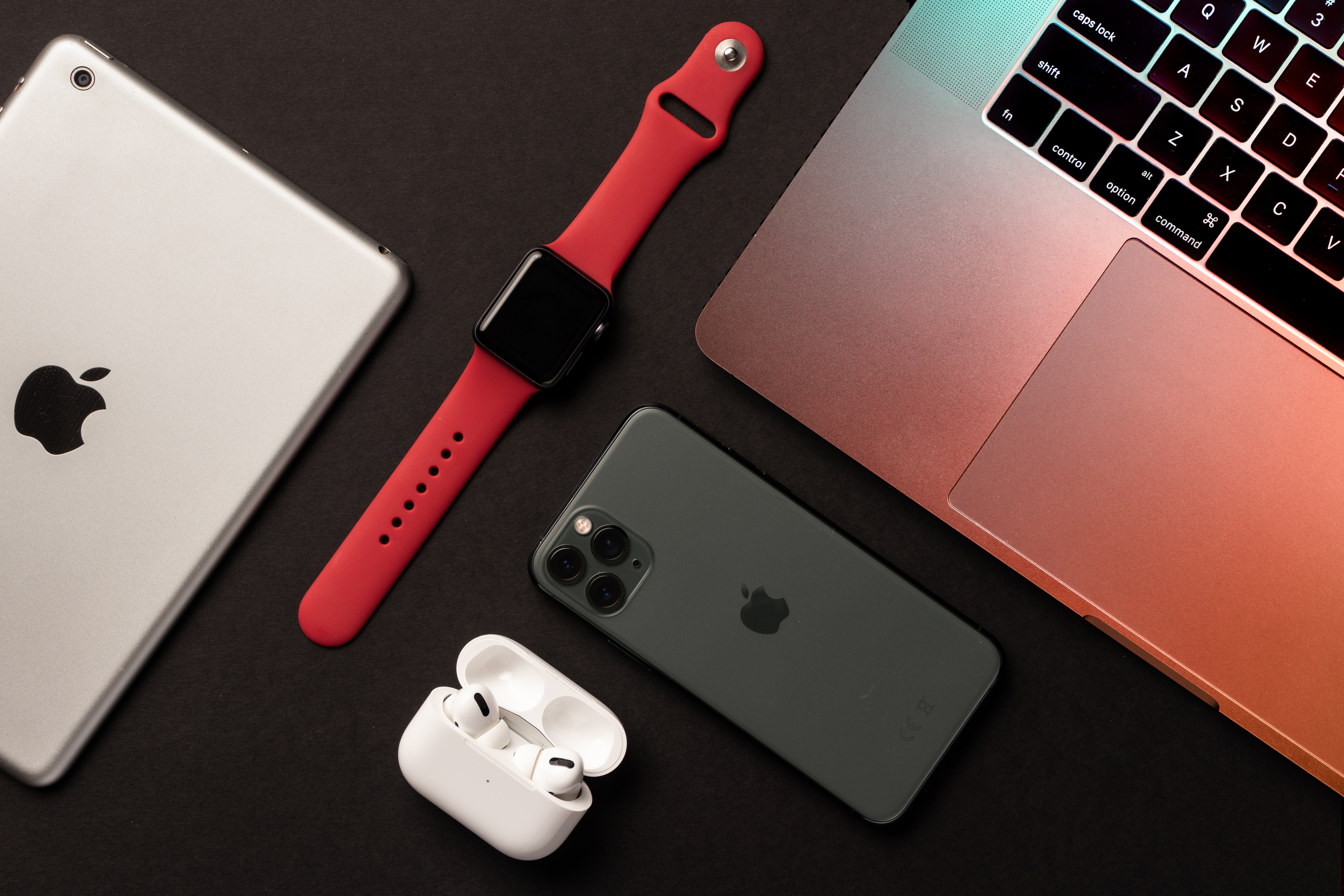 Apple products including iPad, MacBook, iPhone, Apple Watch, and AirPods