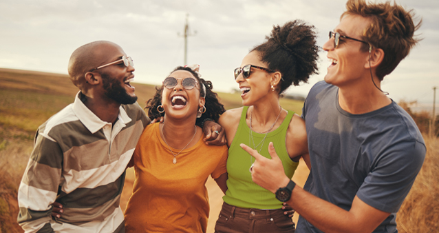 Four young people smiling and embracing, representing the peace of mind provided by comprehensive medical aid