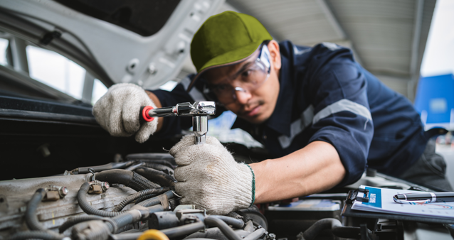 Professional mechanic conducting authorized motor warranty service inspection