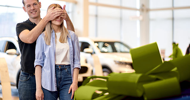 Couple exploring options after cancelled car insurance at car showroom