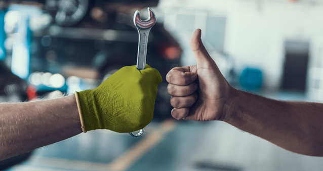 Professional mechanic giving thumbs up after successful car service and warranty check 