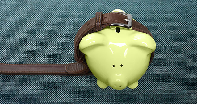 Green piggy bank wearing a brown belt, symbolizing tightening finances with car insurance