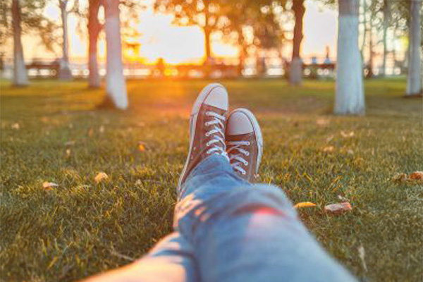 Guy relaxing legs stretched on grass